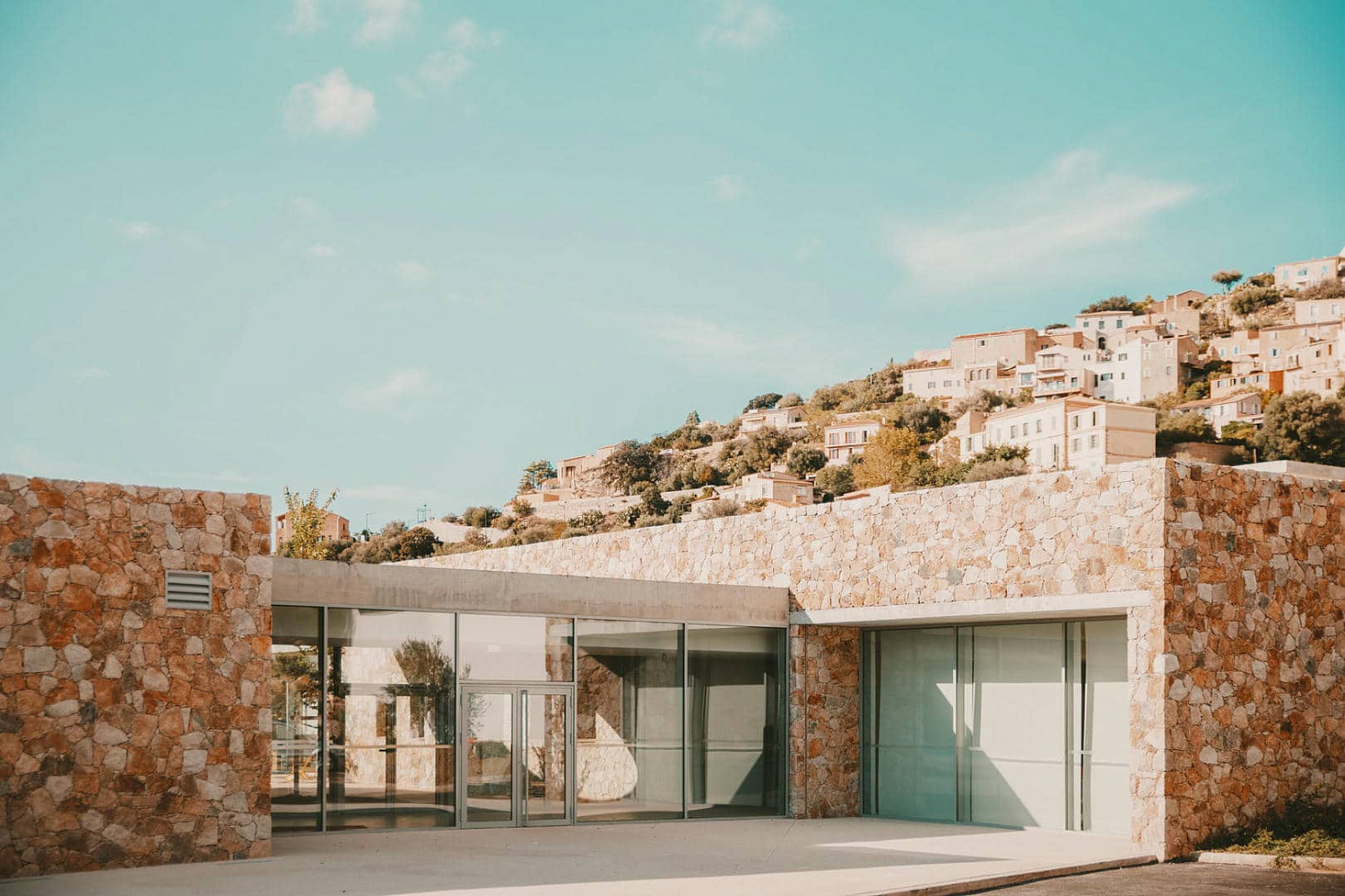 Amelia Tavella Architectes завершает строительство школы, облицованной гранитом, на скалистом побережье Корсики
